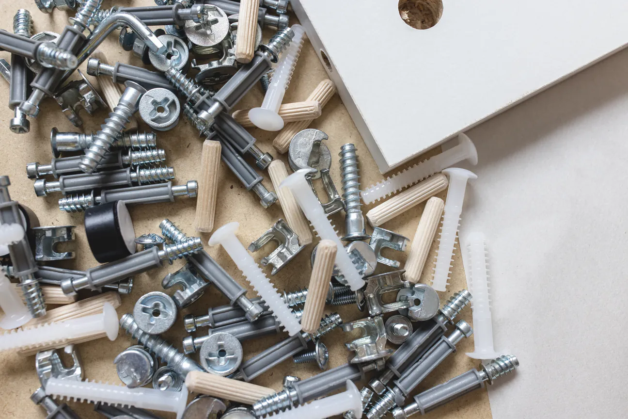 Cam locks, dowels and bolts tipped out of a furniture carton